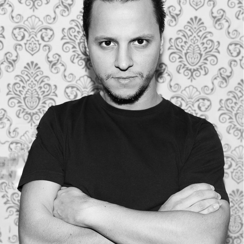 schwarz und weiss Porträt Foto von einem Mann der die Arme verschränkt hält