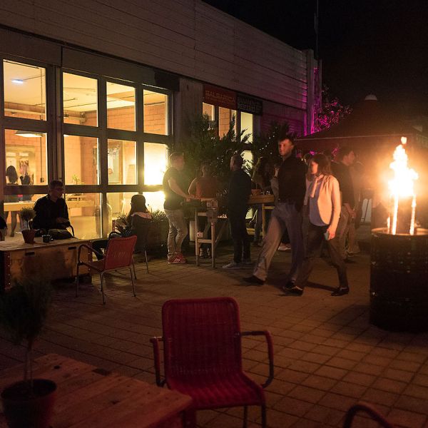 Sommerliche Dachterrasse mit vielen Personen die gemütlich sitzen und etwas Trinken