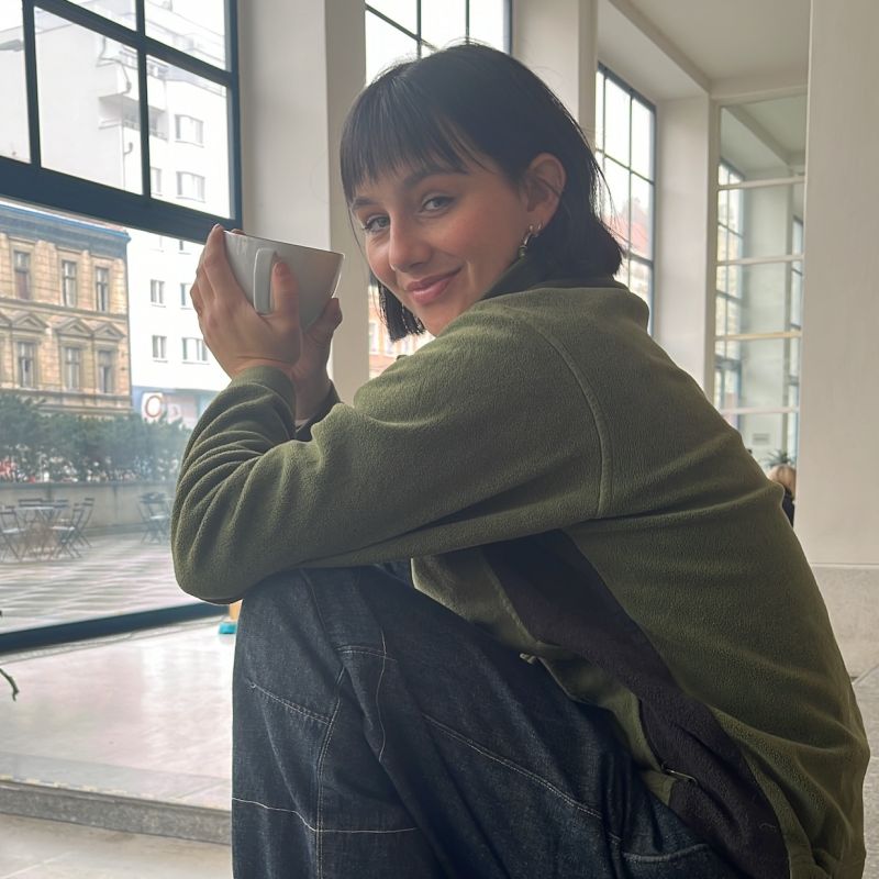 Junge Frau mit einem grünen T-Shirt welche einen machata trinkt