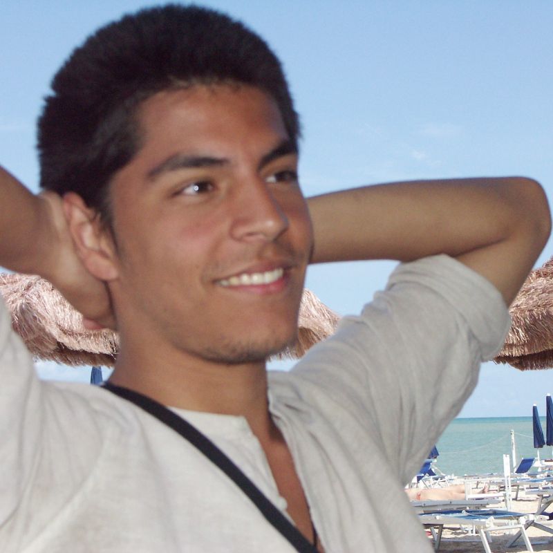 Junger Mann am Strand mit weissem Hemd