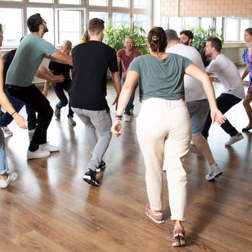 Mehrere Paare tanzen eine Rueda im Kreis