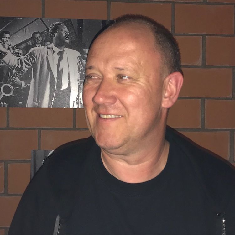 Portrait von einem Mann der lächelt in schwarzer Kleidung