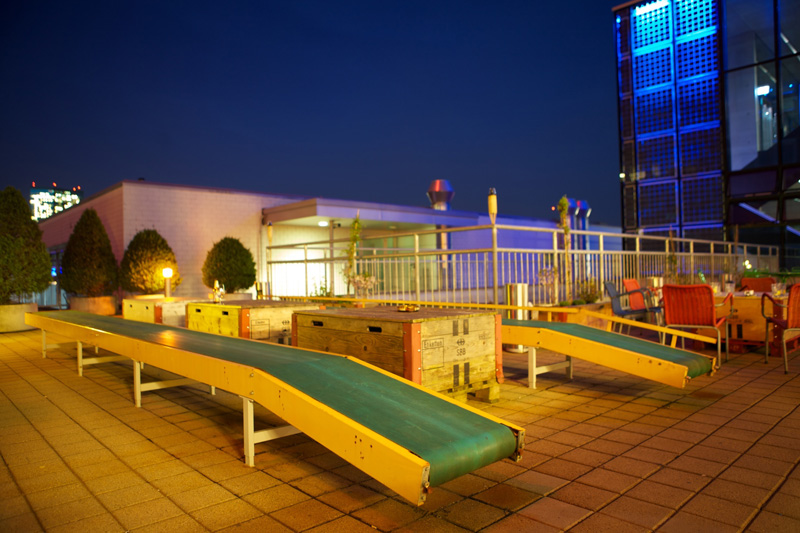 Terasse mit alten Fliessbändern zum Sitzen im Dämmerlicht