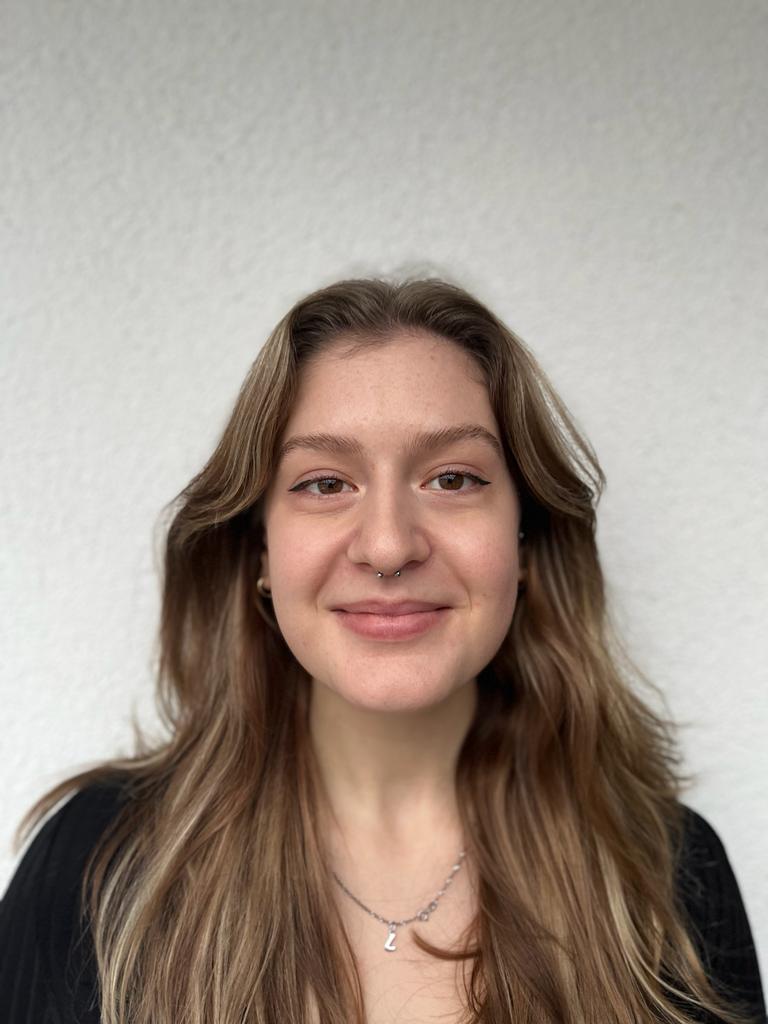 Porträtfoto von einer Frau mit langen hellbraunen Haaren vor einer weissen Wand