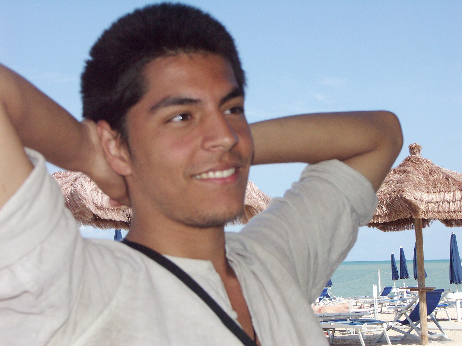 Junger Mann am Strand mit weissem Hemd